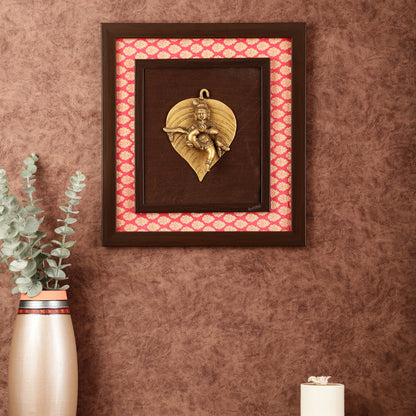 Brass Baby Krishna Baal Gopal Resting on a Leaf Hanging on Wooden Frame with Premium Fabric - 13" x 14"