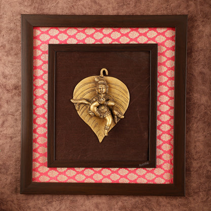 Brass Baby Krishna Baal Gopal Resting on a Leaf Hanging on Wooden Frame with Premium Fabric - 13" x 14"