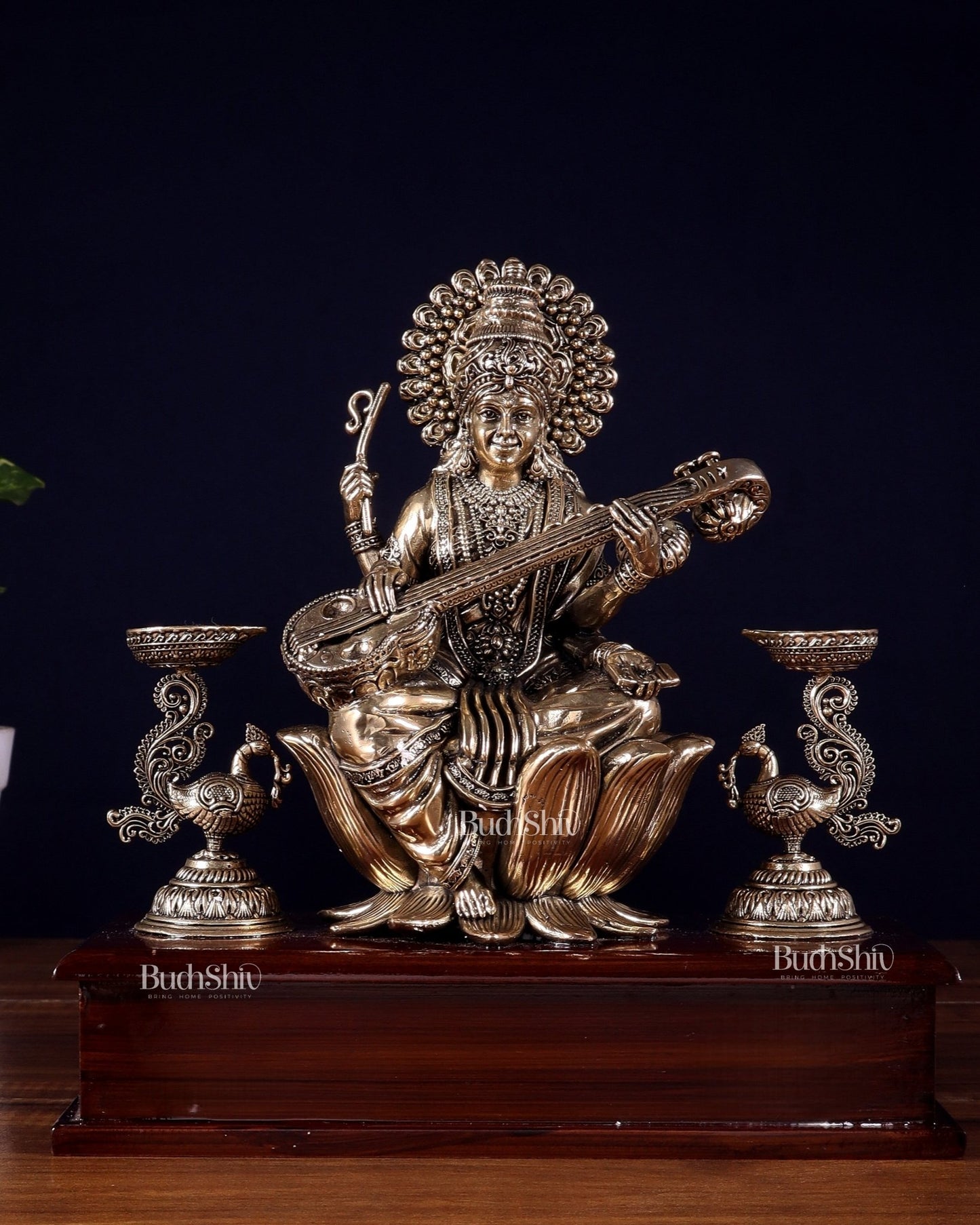 Brass Superfine Goddess Saraswati Idol with Twin Peacock Lamps on Wooden Base – 9.5 Inch - Budhshiv.com