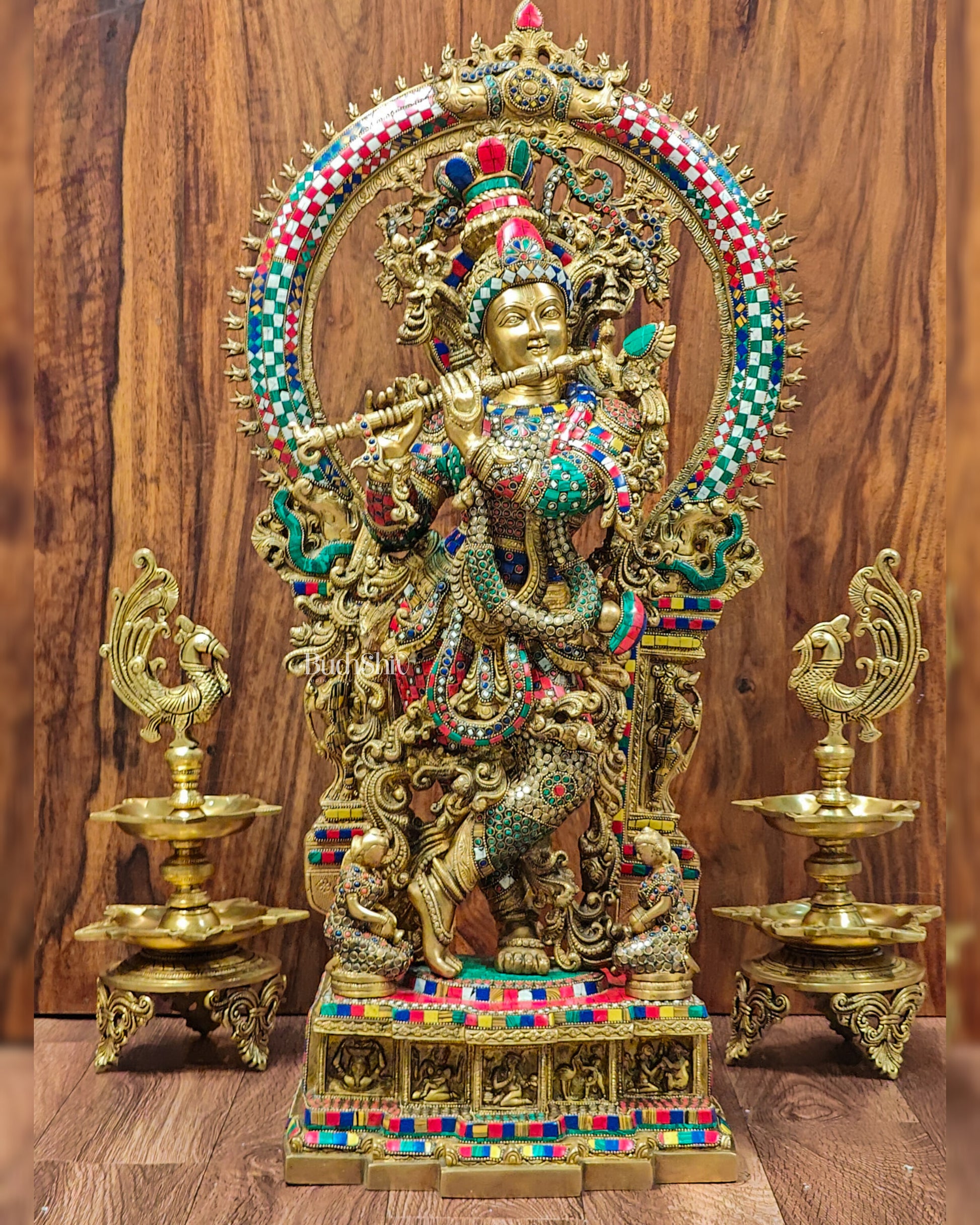Front view of Divine Superfine Brass Krishna Statue with Embossed Prabhavali Frame and Stonework.